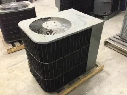 Outdoor air conditioning condenser unit on a wooden pallet in a warehouse.