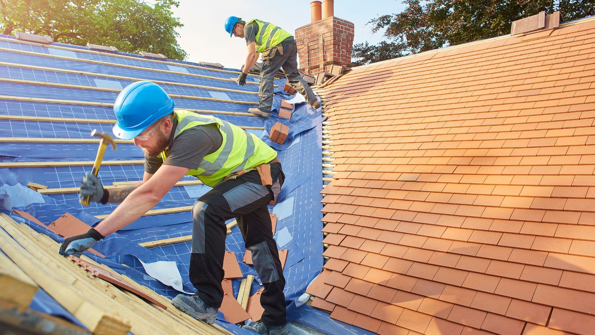 Two men are working on the roof of a house.