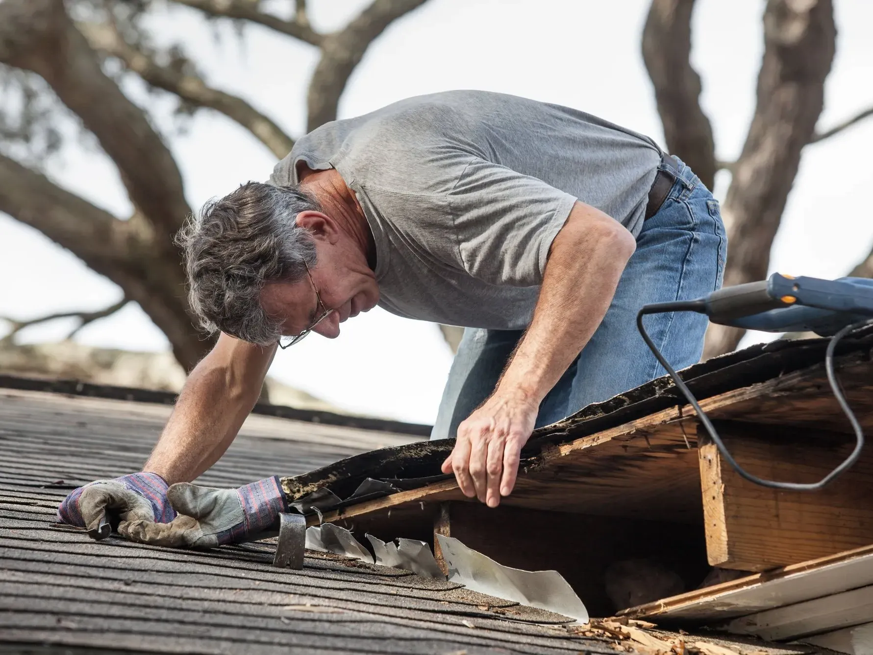 A man is working on the roof of a house.