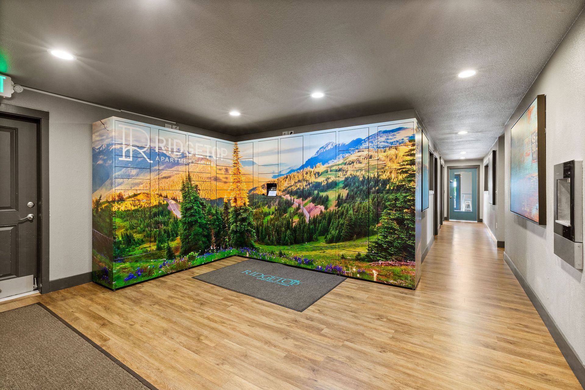 Locker room with landscape mural on lockers, wooden floor, and hallway with artwork.