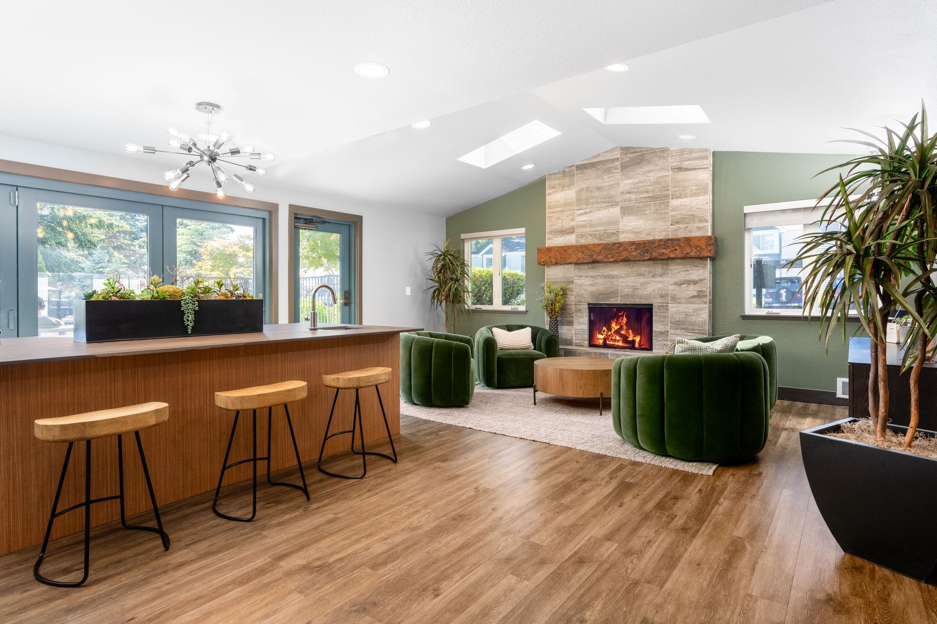 A living room with a fireplace , stools , chairs and a bar.