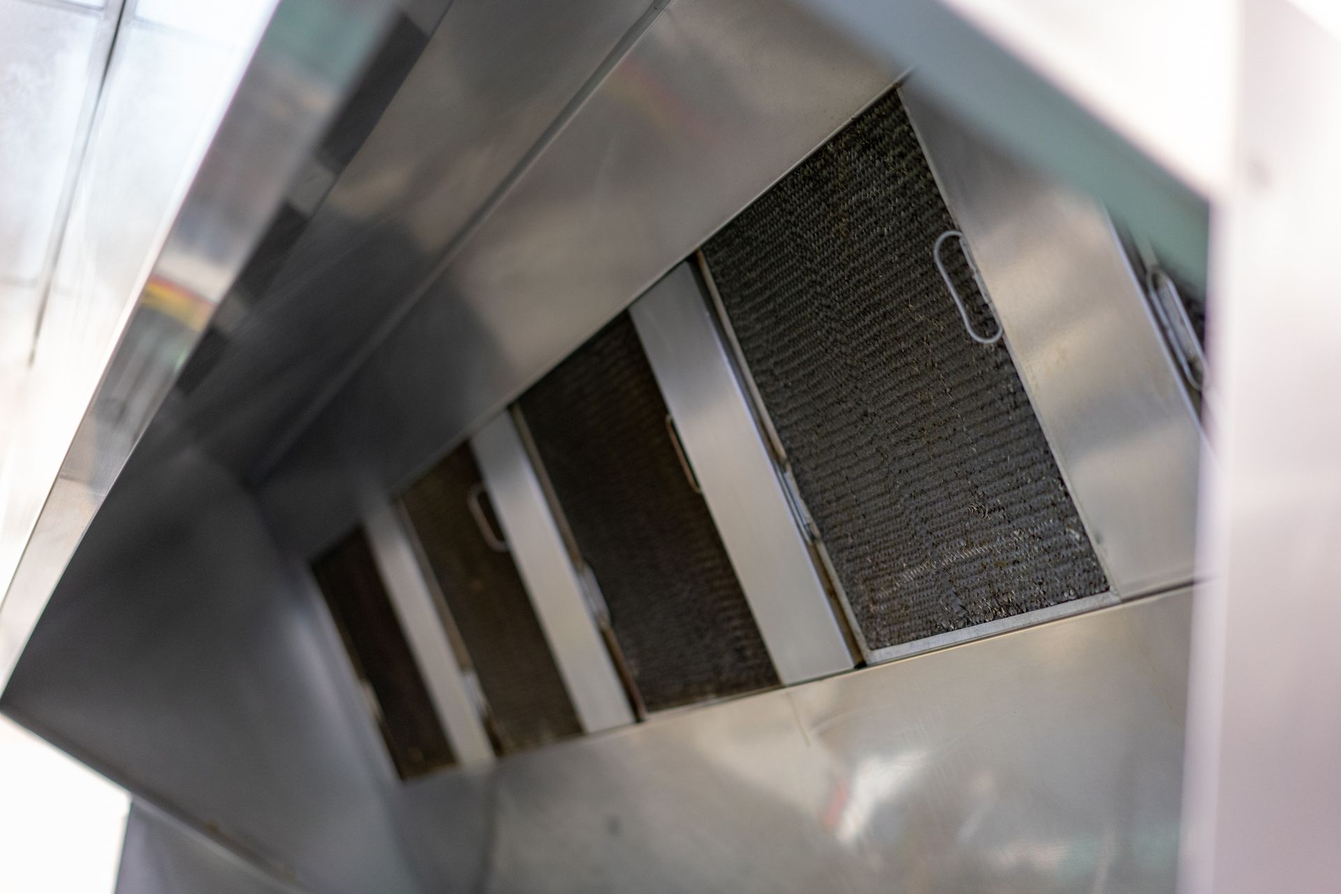 A close up of a stainless steel hood in a kitchen.