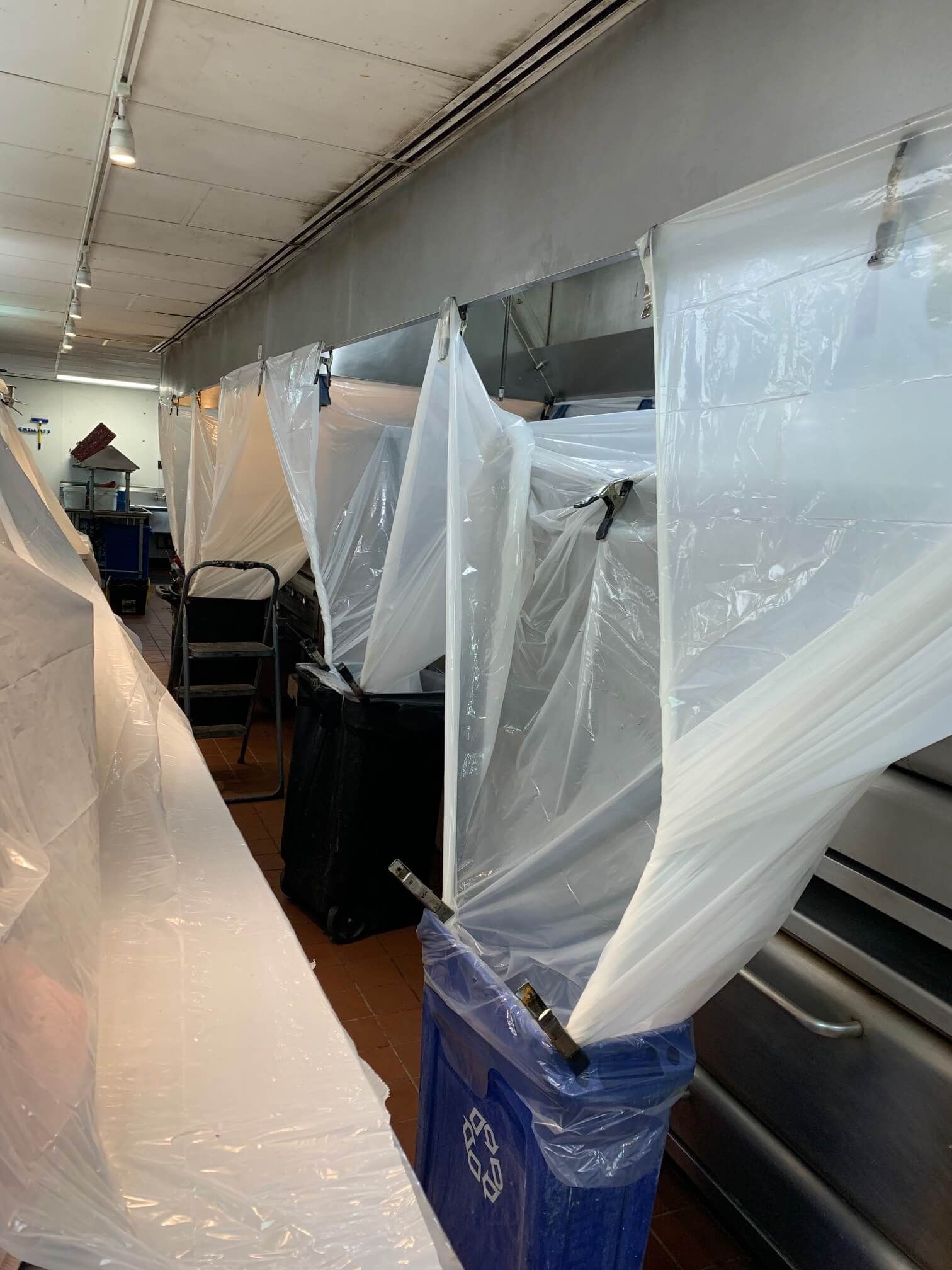 A kitchen with plastic covering the walls and ceiling.