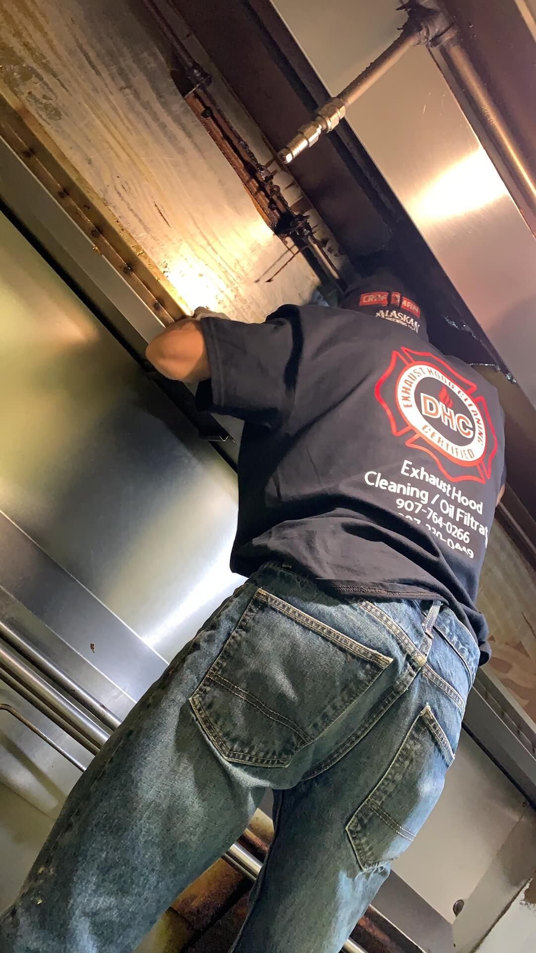 A man is working on a ceiling fan in a kitchen.