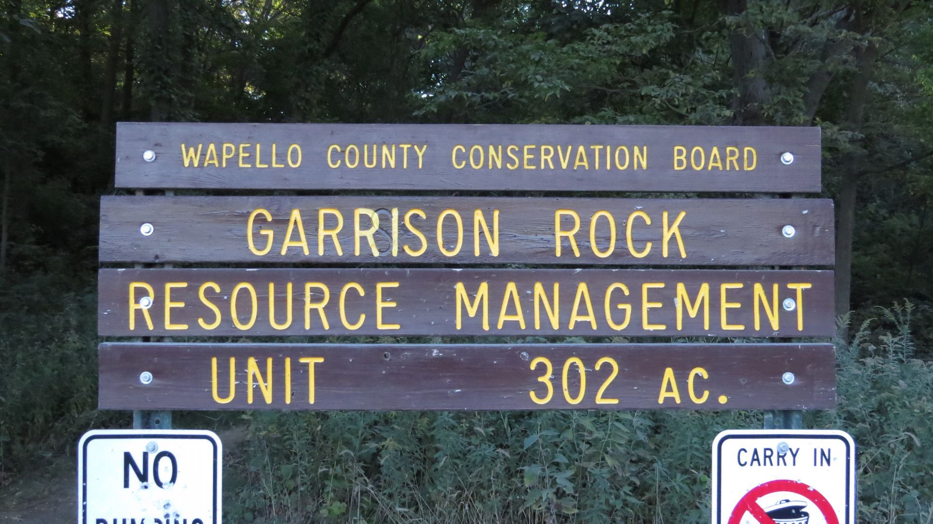 A brown wooden sign reads