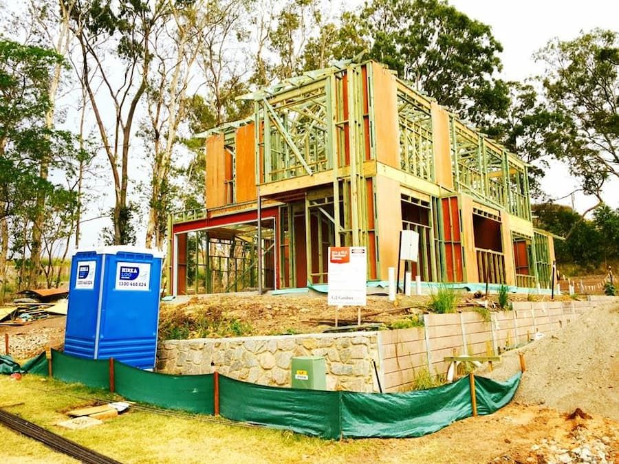 A House is Being Built With Portable Toilets in Front of It — Hire A Loo in Noosa, QLD