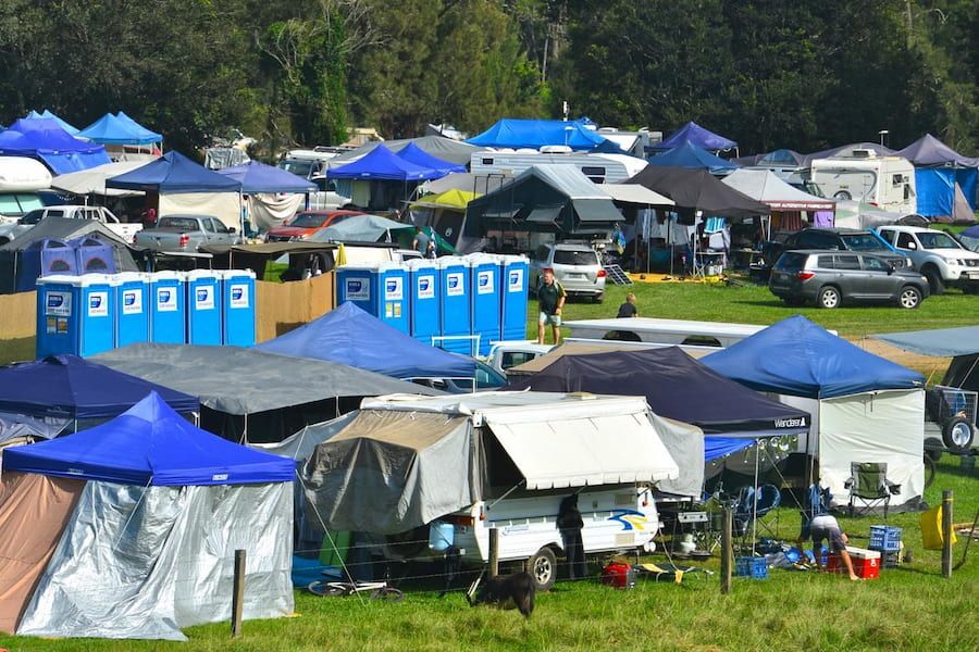 A Large Group of People Are Camping in a Field — Hire A Loo in Noosa, QLD