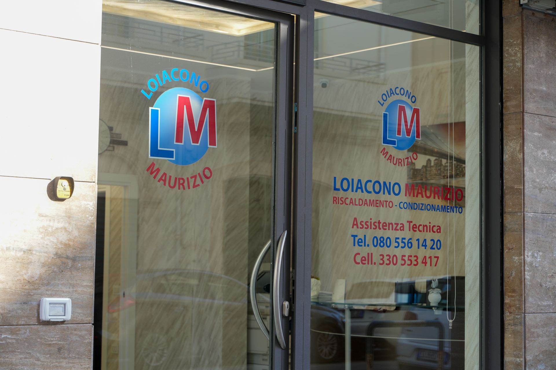 Porta in vetro con logo aziendale blu e rosso;