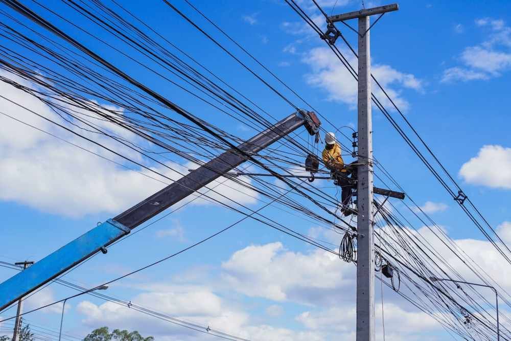 Lineman on a Utility Pole, Working From a Blue Crane — FAW Electrical in Nowra Hill, NSW