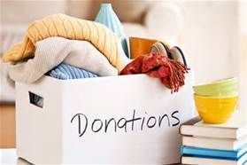 White donation box filled with clothes, bowls, and books. 