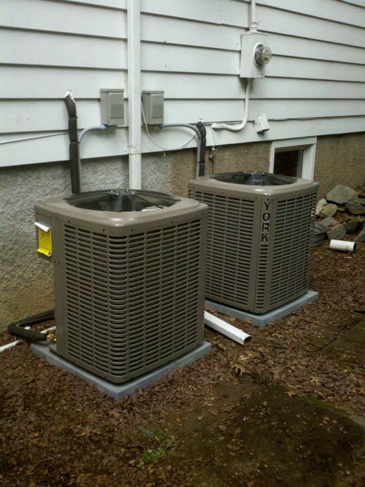 Two York air conditioning units outside a white house.