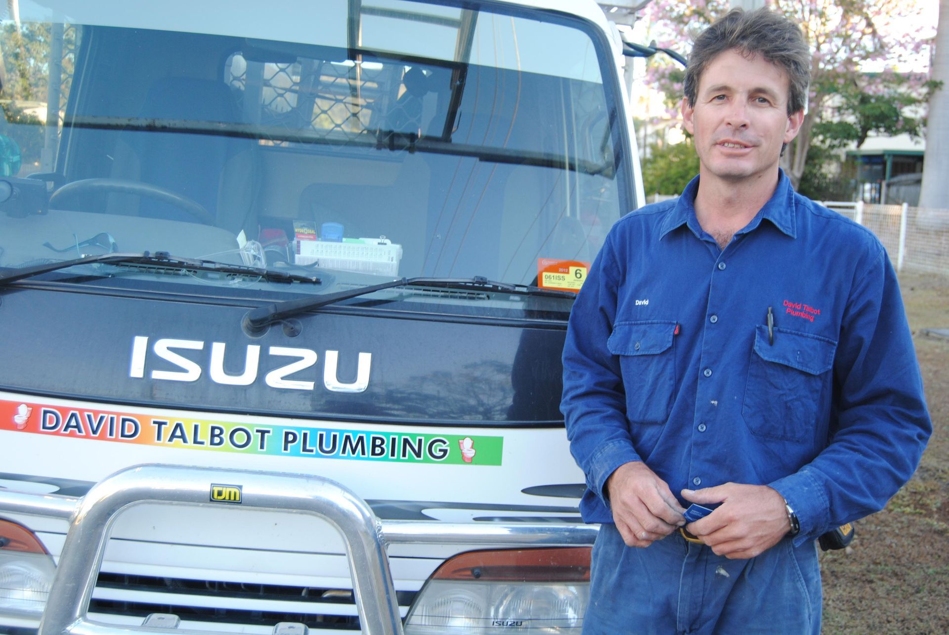 Man Standing In Front Of Isuzu Van — David Talbot Plumbing in Cranbrook, QLD