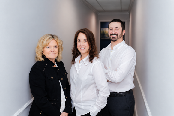 The Horne Insurance Agency team members are posing for a picture in a hallway.