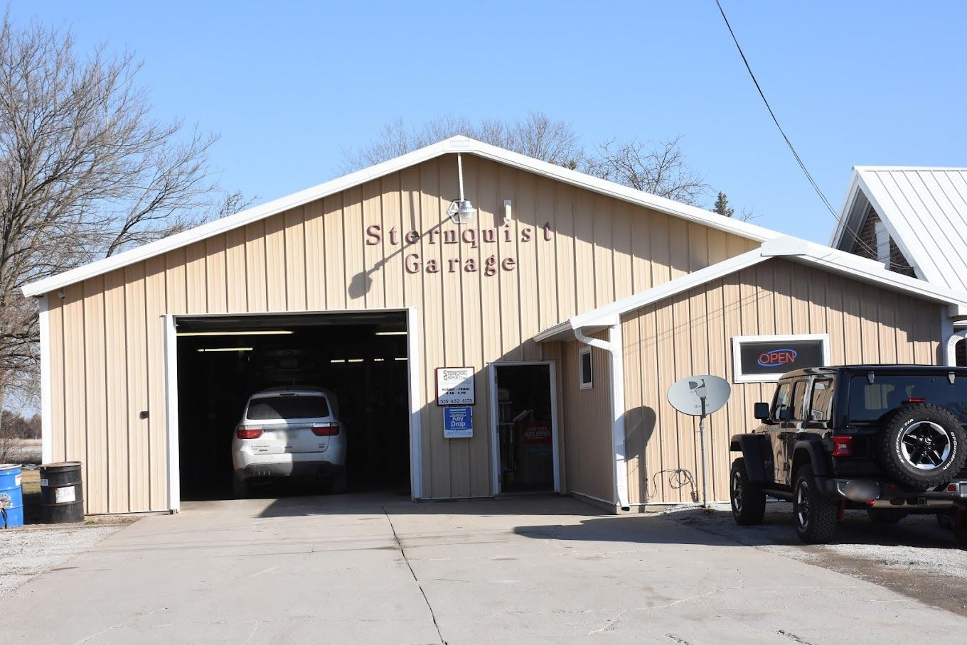 A car is parked in front of a garage.