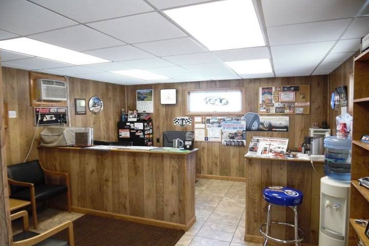 A waiting room with a blue stool and a water cooler