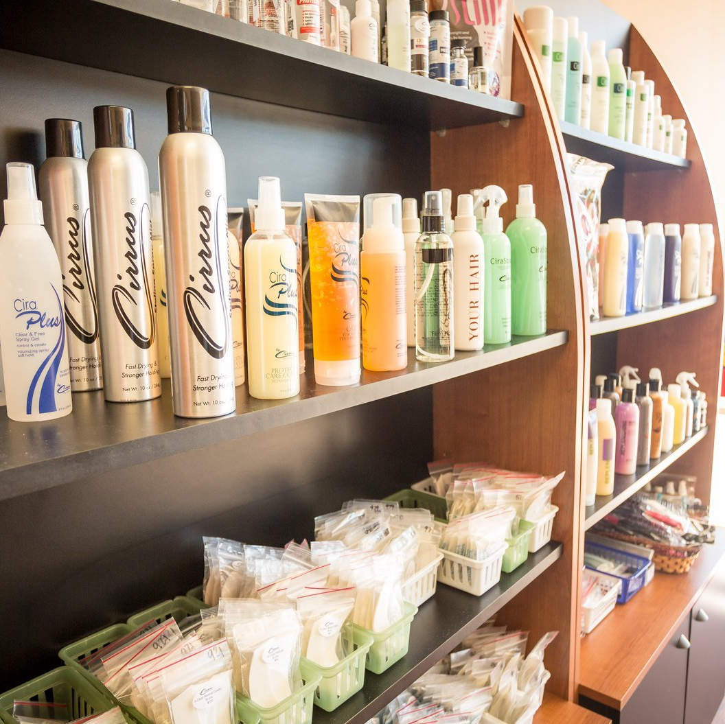 A shelf full of hair products including a spray bottle that says ' keratin ' on it