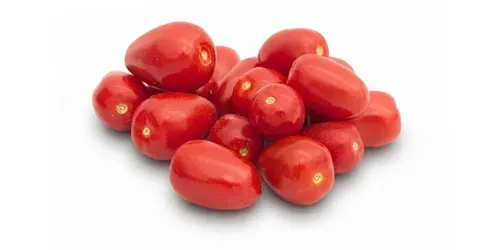 Een stapel glanzende rode snoep tomaten op een witte achtergrond.