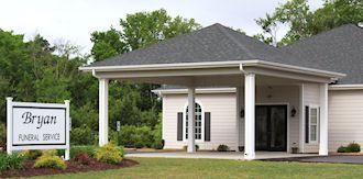 Bryan Funeral Home building with a white sign and landscaped entrance