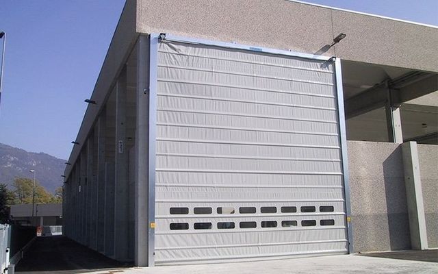 Un edificio con una grande porta da garage e montagne sullo sfondo