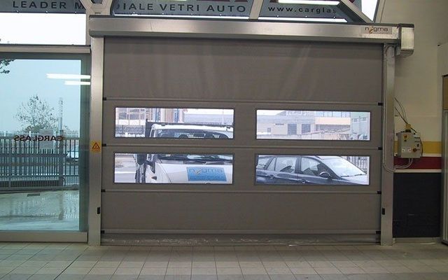 Un'auto è parcheggiata davanti a una porta su cui è scritto "leader"