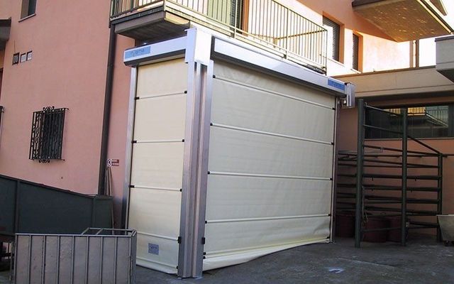 Una grande porta bianca è posizionata all'esterno di un edificio