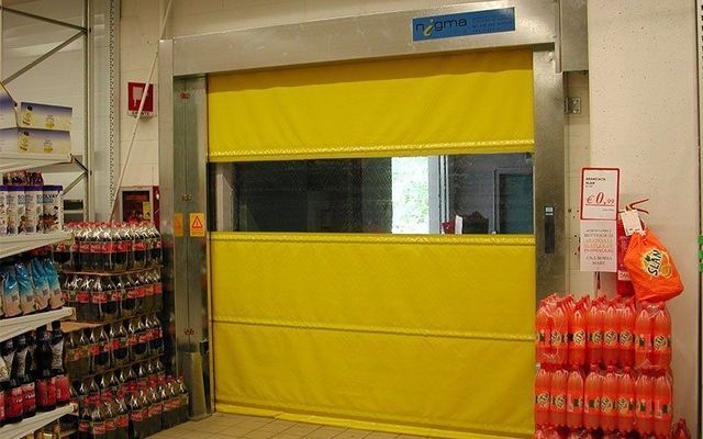 Una porta gialla in un negozio accanto a una pila di bottiglie di soda.