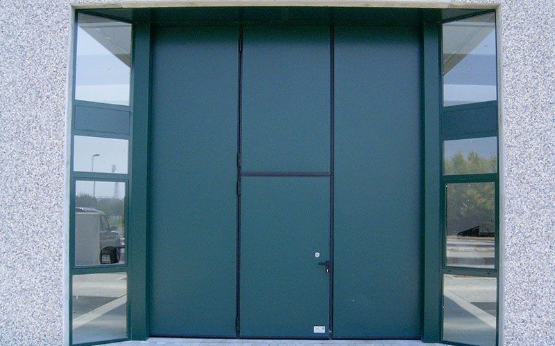 Una grande porta verde con tante finestre