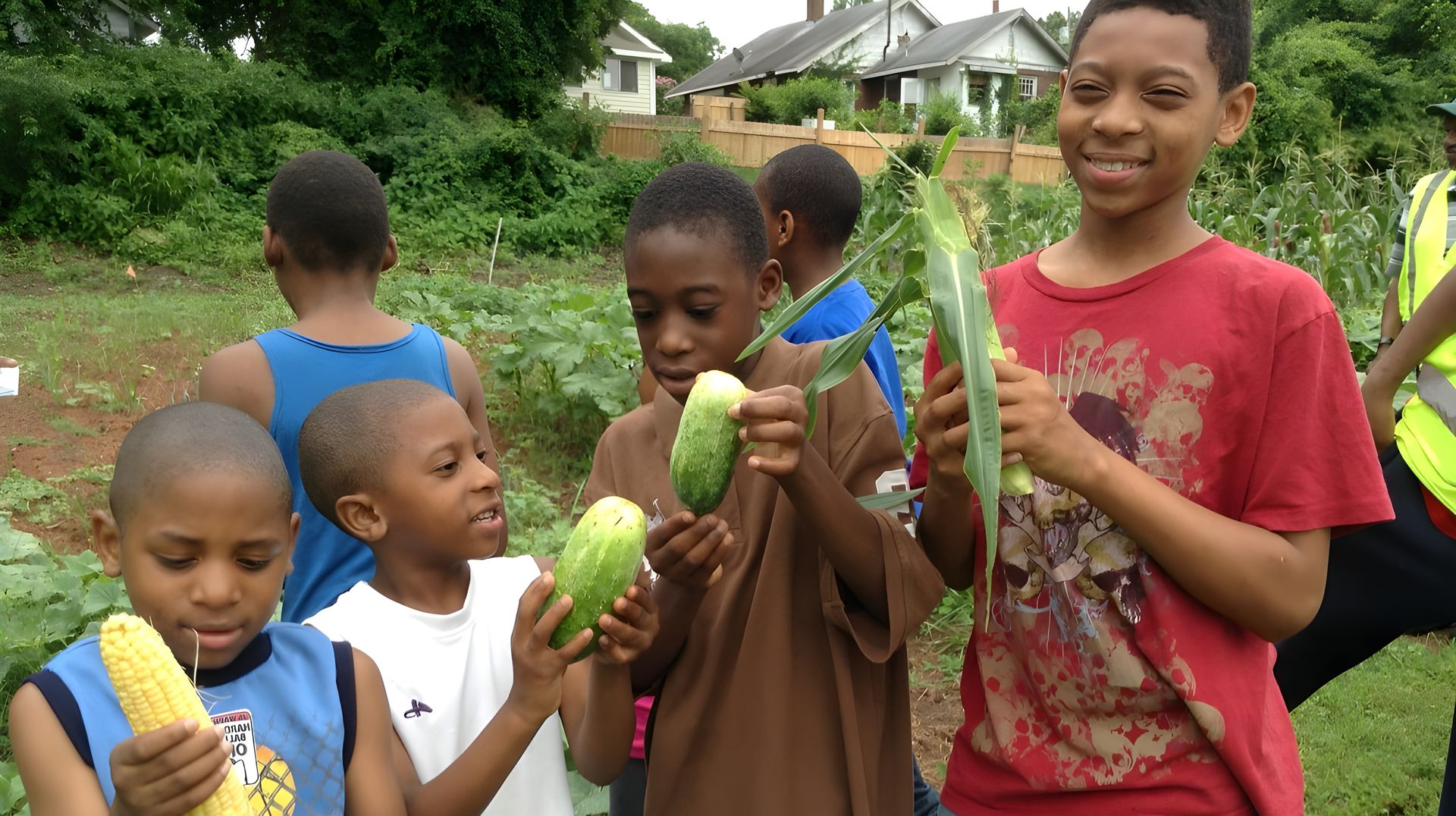 A group of children holding vegetables in a garden, with a sign reading