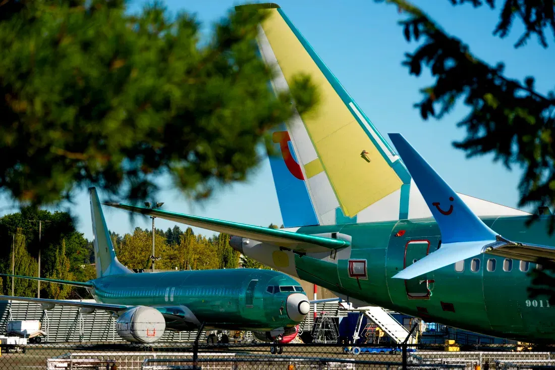 Two planes are parked next to each other on a runway.