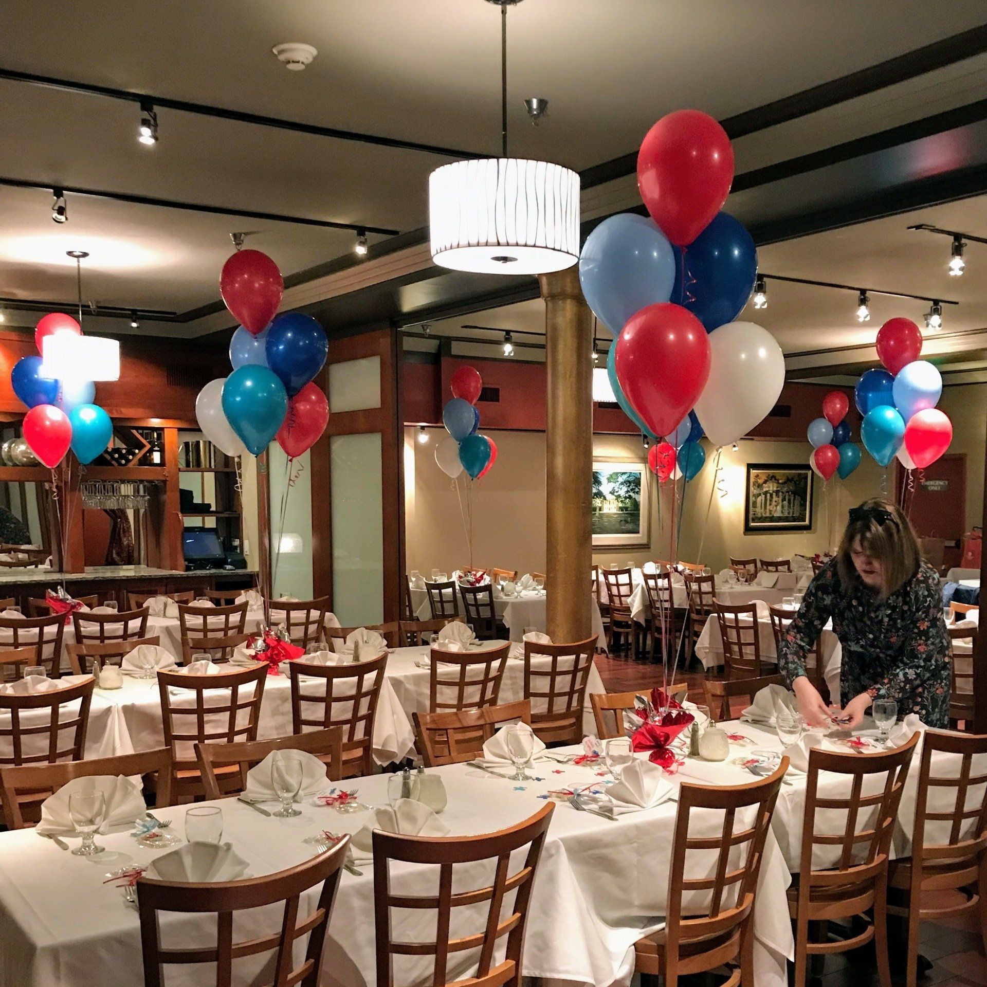 Red, white, and blue 6-balloon bouquet centerpieces  at a restaurant with custom foil weights.