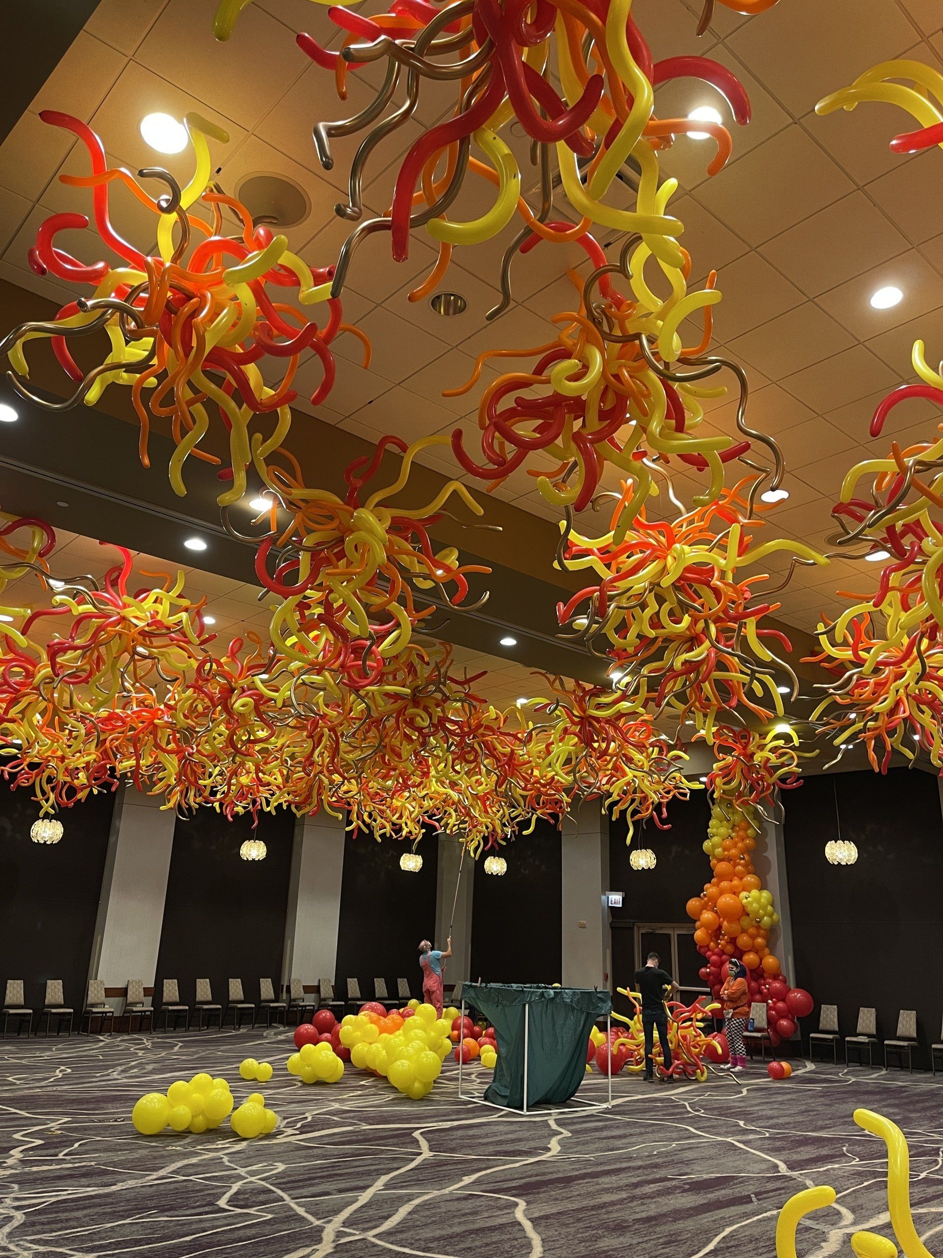 Hotel ballroom with a fun balloon fire ceiling in yellow, red, and orange. 