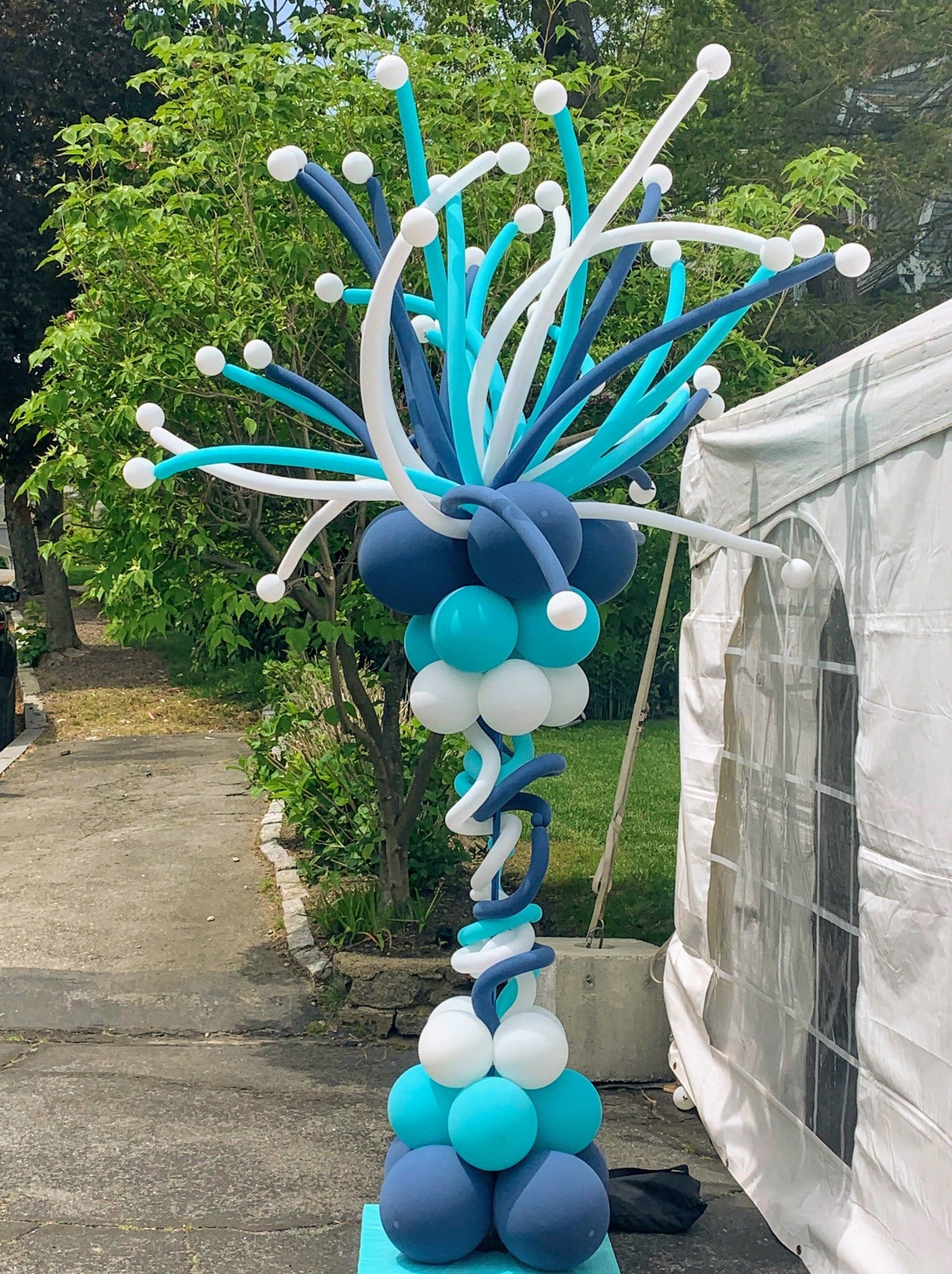 Firecracker Balloon column in blue and white, outdoors next to a tent.
