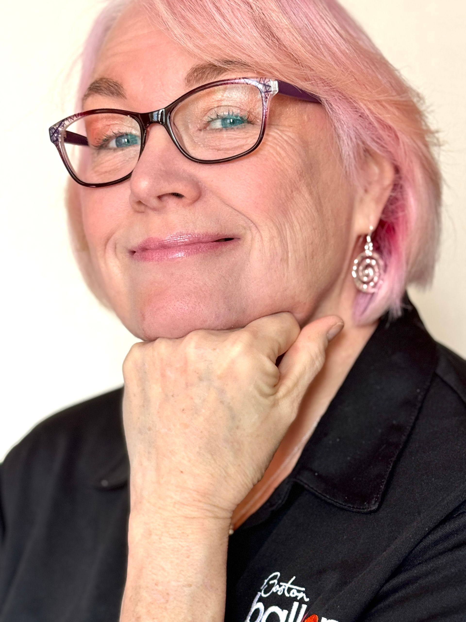 Amy, Lead balloon stylist at Boston Balloon Art with pink hair and glasses smiling.