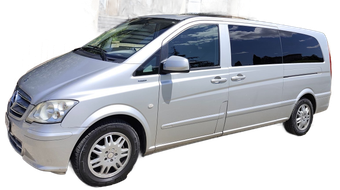 Minivan argentato visto frontalmente da sinistra su sfondo bianco.