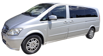 Minivan argentato su sfondo bianco, vista frontale sinistra angolata.