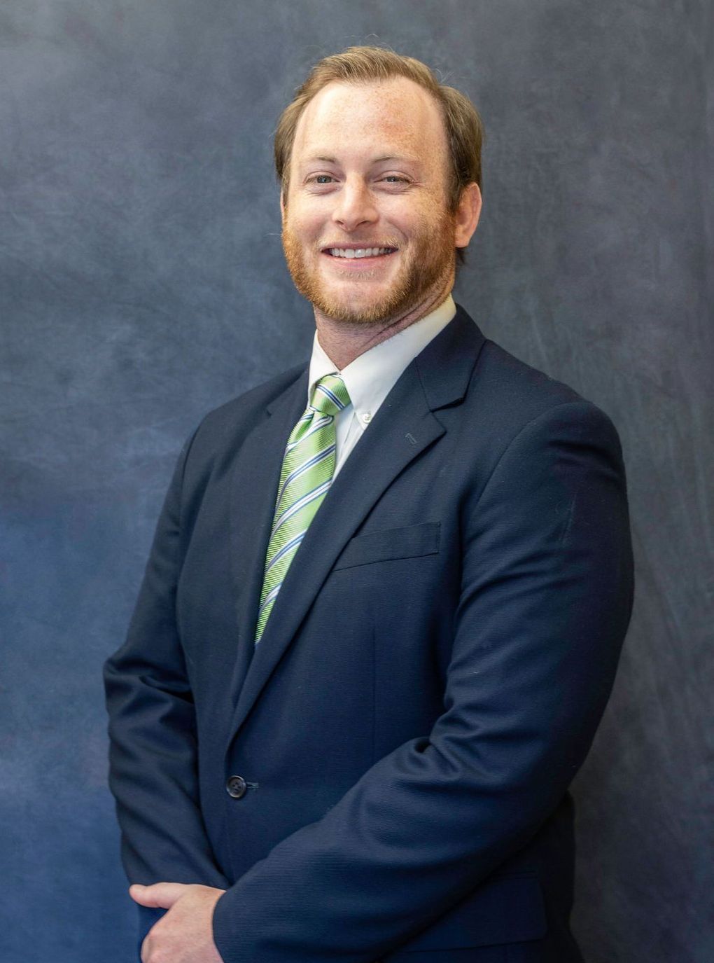 A man in a suit and tie is smiling for the camera.