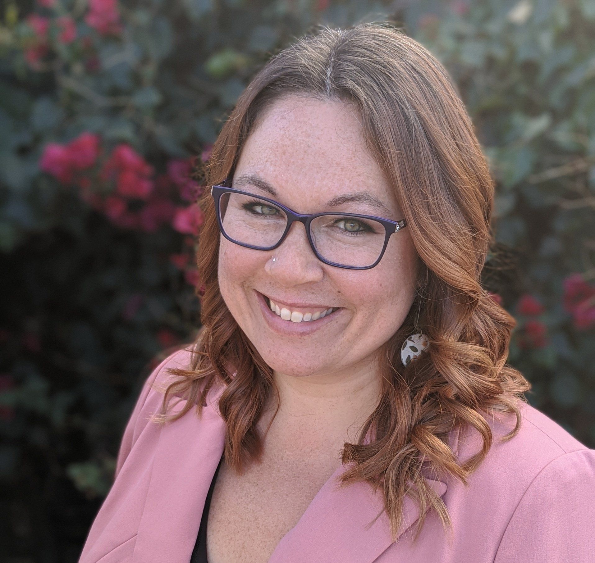 A professional headshot of Roya Dedeaux, LMFT, with a warm smile and a confident gaze. She is dressed in business attire, with her hair styled neatly. The image conveys competence, professionalism, and approachability, making her an ideal choice for therapy services.