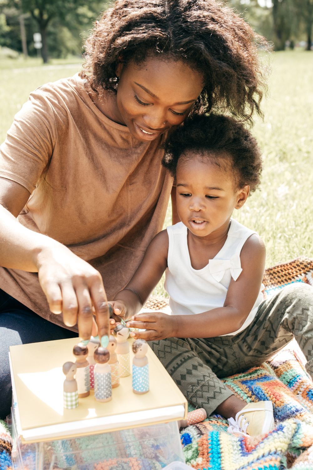 Mother and daughter playing with peg dolls