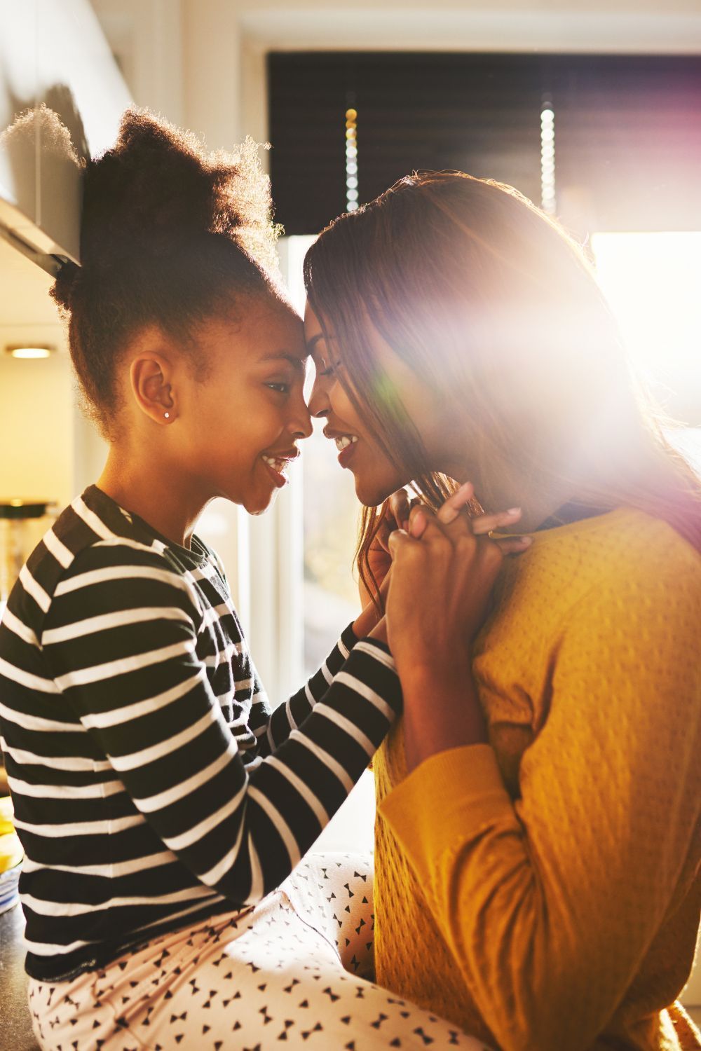 Mom and daughter foreheads together