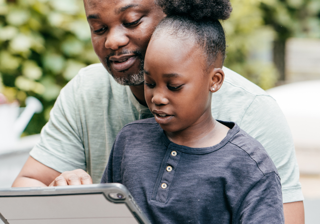 Father and daughter looking at a tablet
