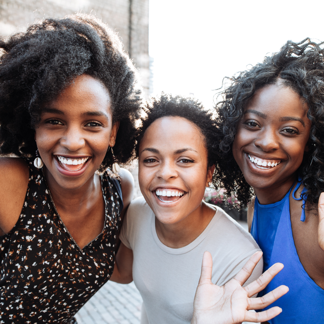 A Smiling Family of a Black Mom with two Black teen daughters