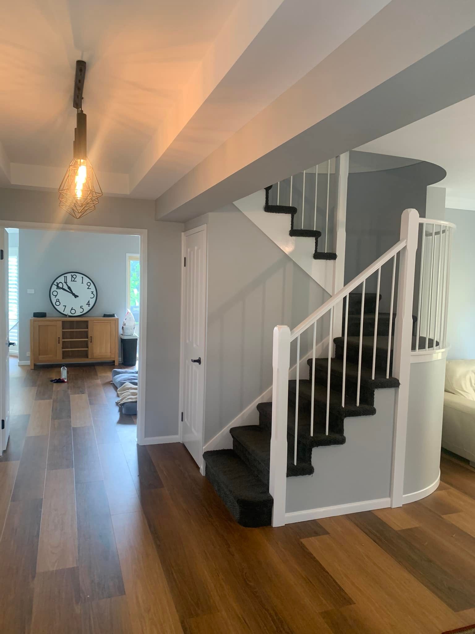 A Staircase in a House With a Clock on the Wall — Karl Witt Painter & Decorator In Oak Flats, NSW
