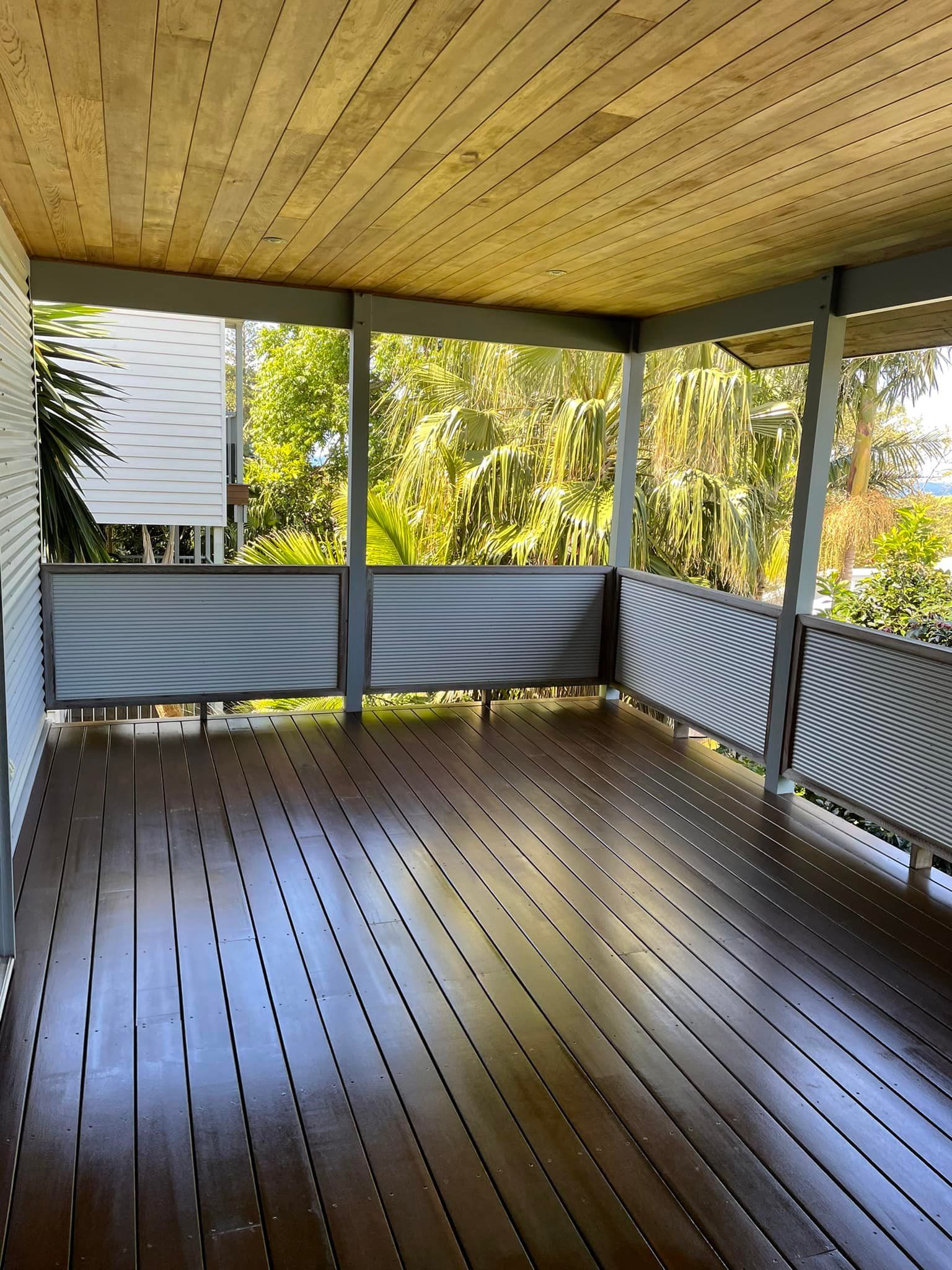 An Empty Porch With a Wooden Floor and a Metal Railing — Karl Witt Painter & Decorator In Kiama, NSW