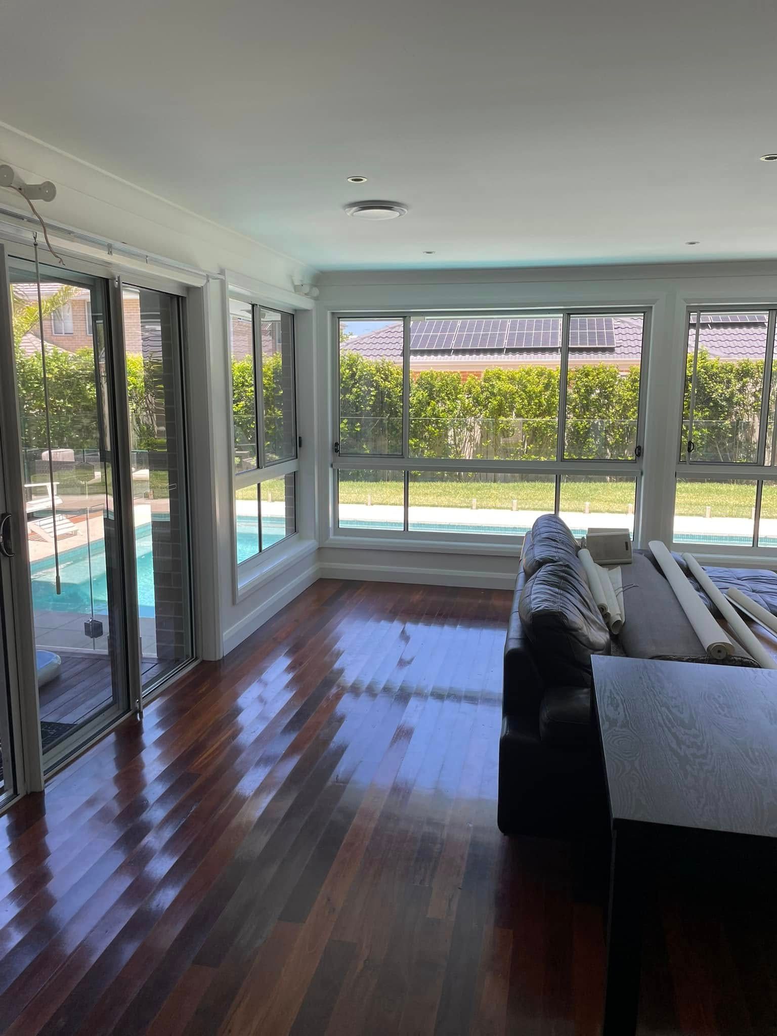 A Living Room With a Couch , Table , and Lots of Windows — Karl Witt Painter & Decorator In Albion Park, NSW