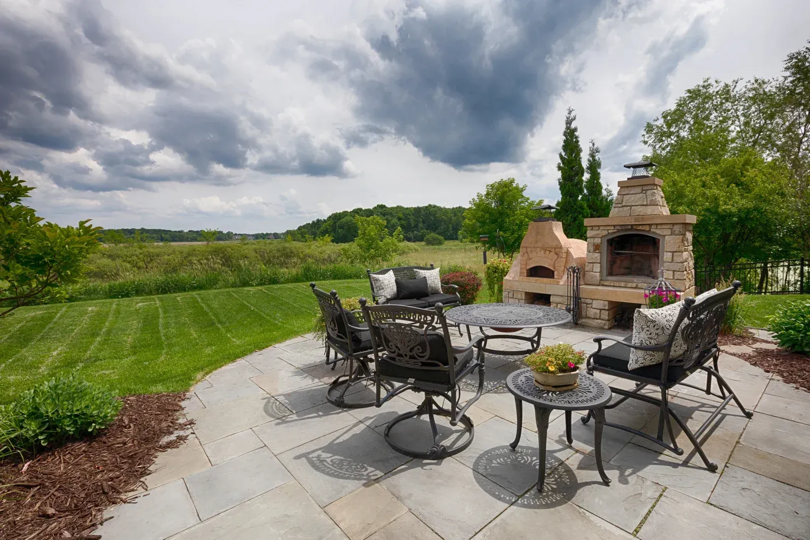 A patio with a table and chairs and a fireplace