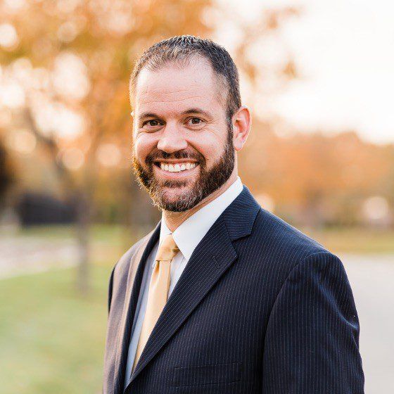 A man in a suit and tie is smiling for the camera.