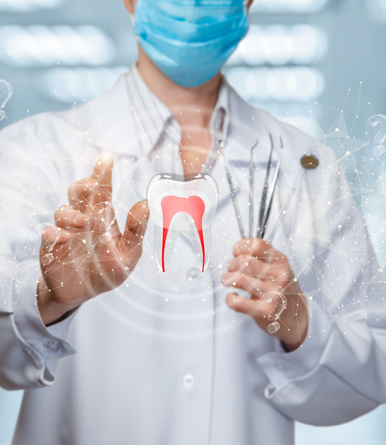A dentist wearing a mask is holding a tooth and dental tools.