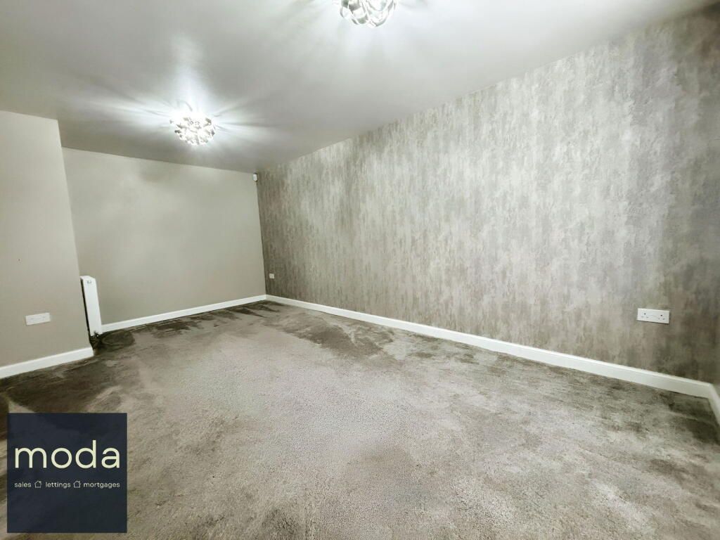 Empty room with gray carpet, textured wall and two lights.