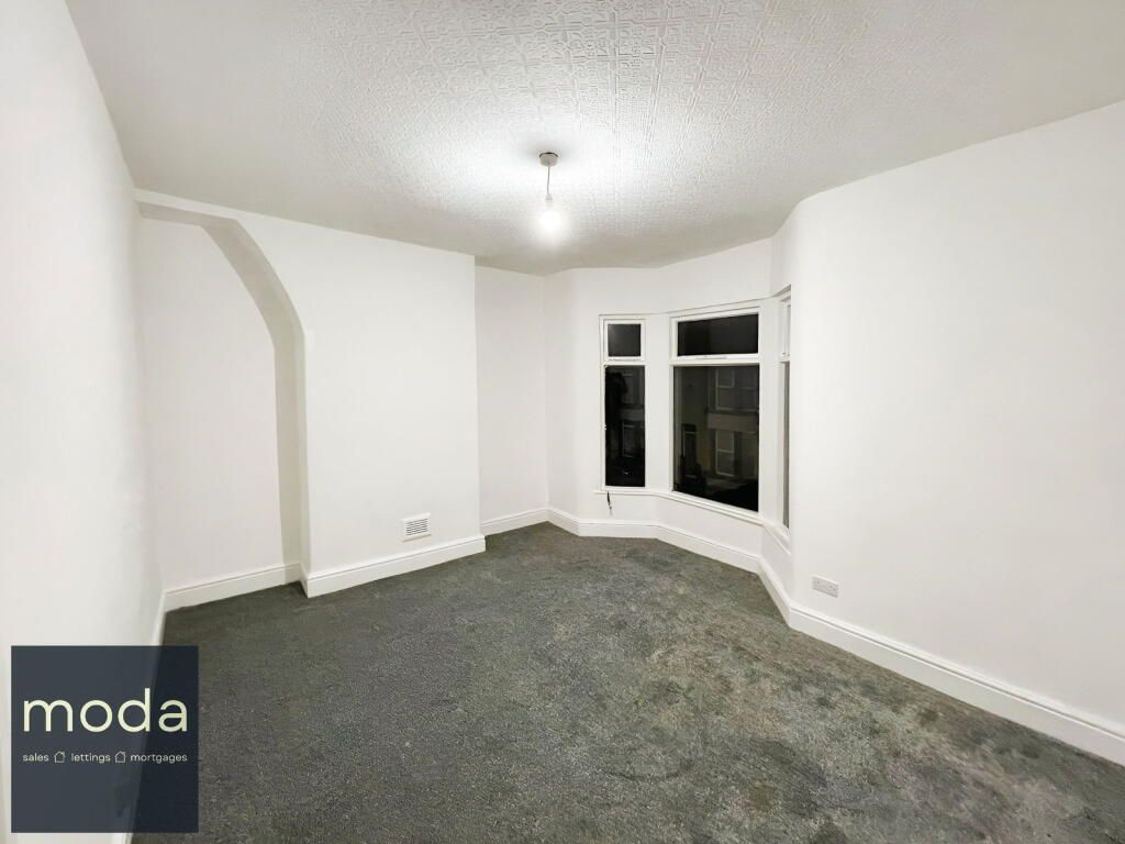 Empty room with gray carpet, a bay window, and white walls.