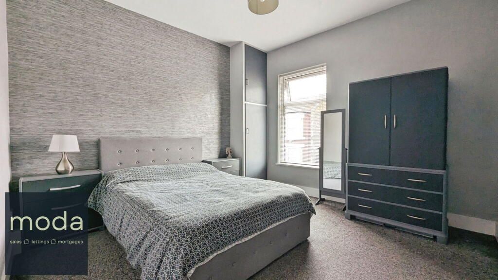 Grey bedroom with double bed, wardrobe, nightstand, and full-length mirror.